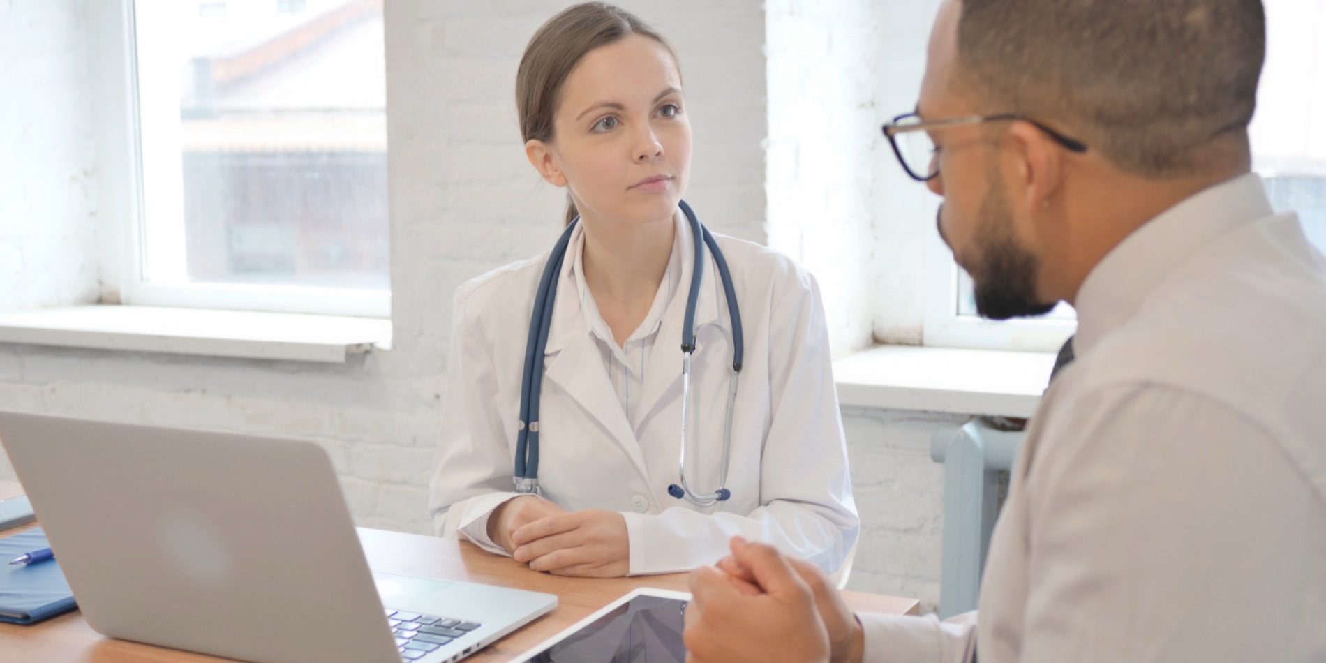 Female Doctor Talking with Patient in Hospital